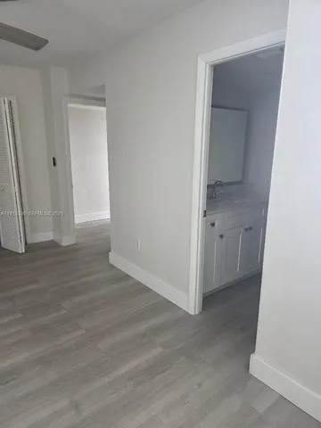 an empty room with wooden floor and mirror