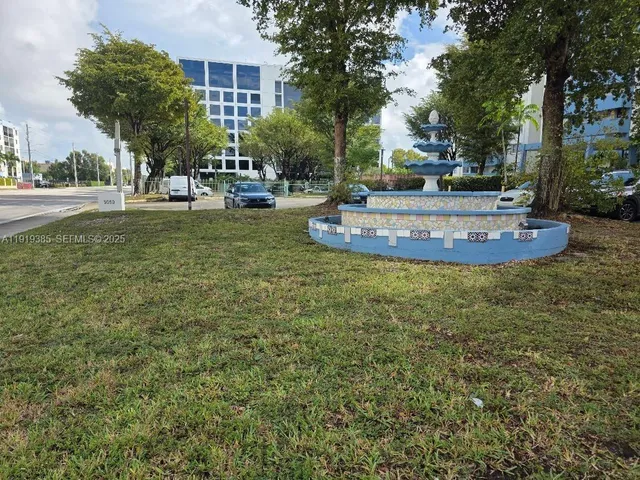 a view of a building with trees and yard