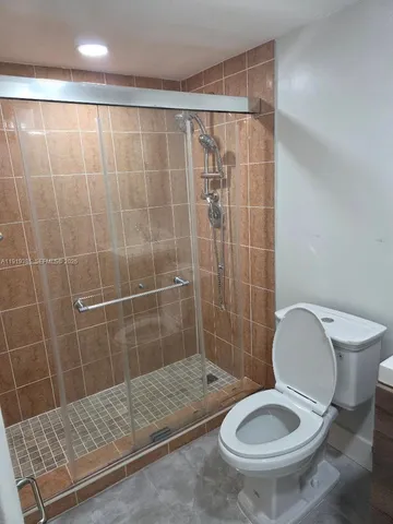a bathroom with a toilet and a shower