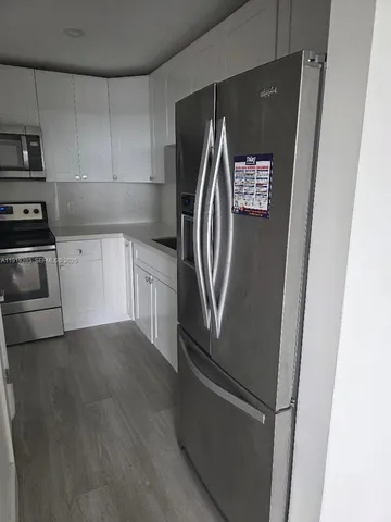 a metallic refrigerator freezer sitting in a kitchen