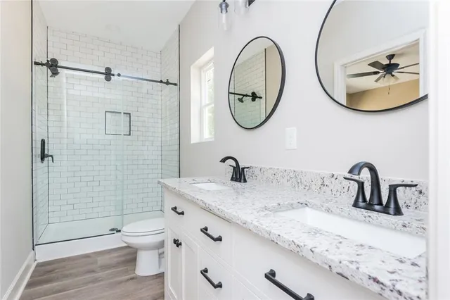 a bathroom with a granite countertop sink a toilet and a mirror
