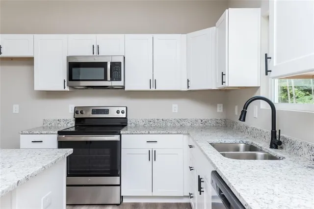 a kitchen with appliances a sink and cabinets