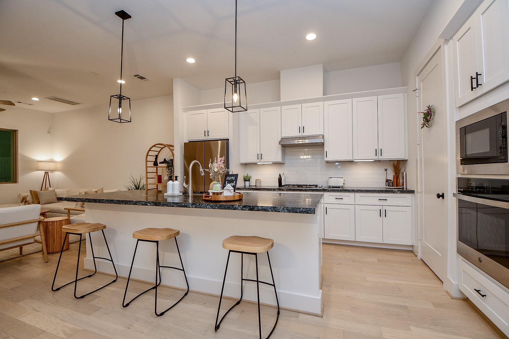 4403 Greeley Street Houston, TX 77006 - Photo 6 of 28 a kitchen with stainless steel appliances granite countertop a kitchen island a stove a sink a dining table and chairs