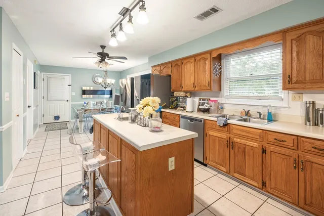 a kitchen with a sink a stove a refrigerator cabinets and dining table