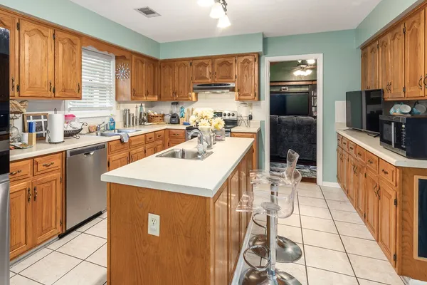 a kitchen with a sink a stove a refrigerator and cabinets