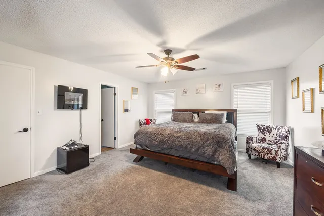 a spacious bedroom with a bed and a flat screen tv