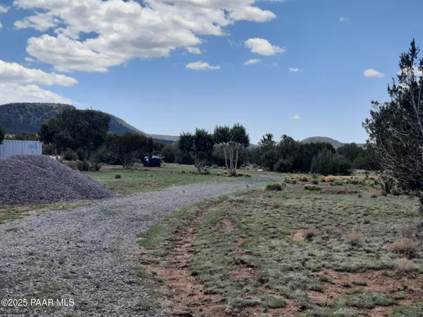 a view of a dry yard with a house in the background