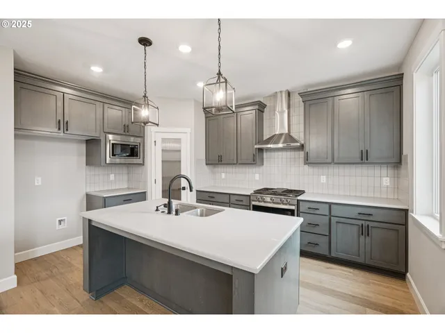 a kitchen with stainless steel appliances a sink stove and refrigerator