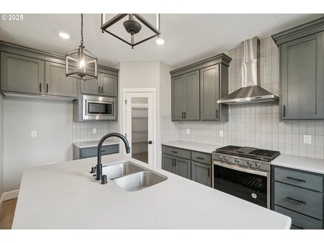 a kitchen with stainless steel appliances a sink a stove and cabinets