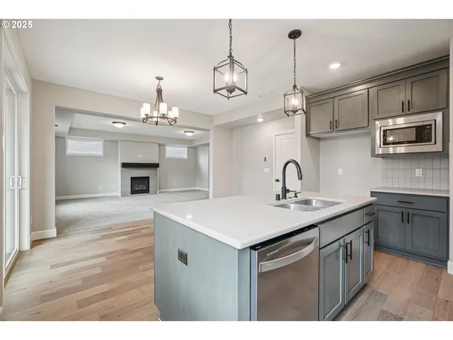 a kitchen with kitchen island a sink stainless steel appliances and cabinets