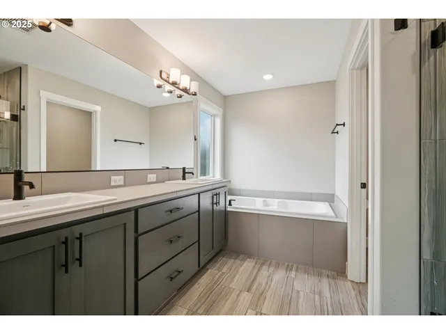 a bathroom with a tub sink and mirror