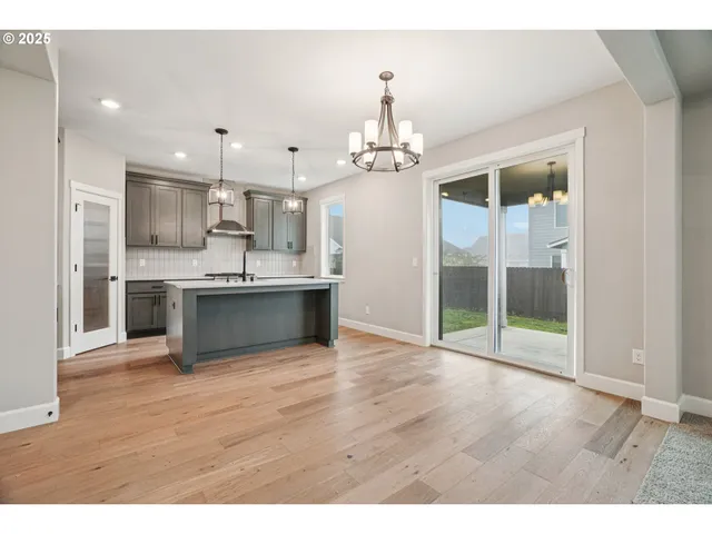 a view of kitchen with refrigerator and wooden floor
