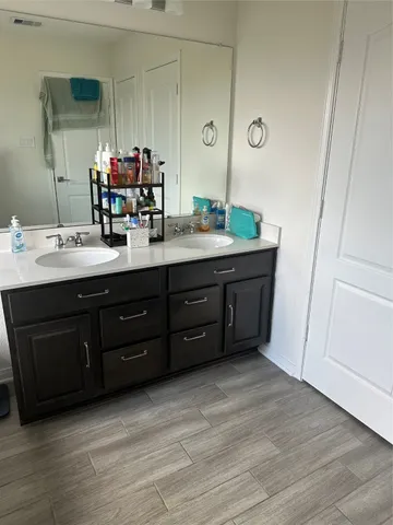 a bathroom with a double vanity sink and a mirror