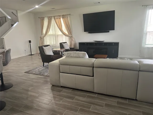 a living room with furniture a flat screen tv and a fireplace