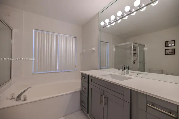 a bathroom with a tub a sink and mirror