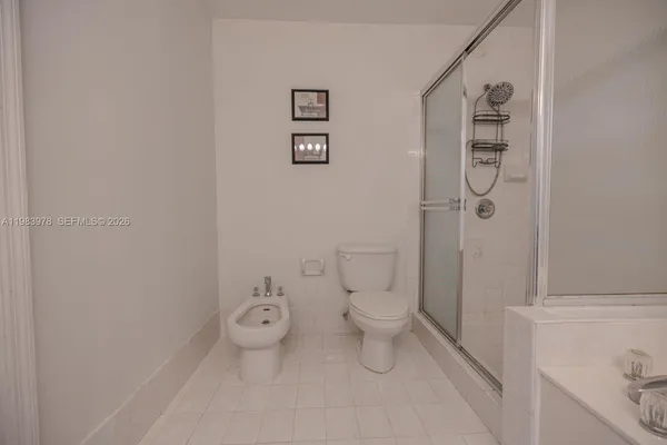 a white toilet sitting next to a bathroom sink and vanity