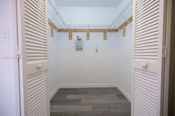 a view of a small space with wooden floor and a window