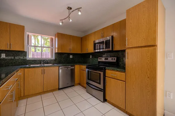 a kitchen with stainless steel appliances granite countertop a stove a sink and a refrigerator
