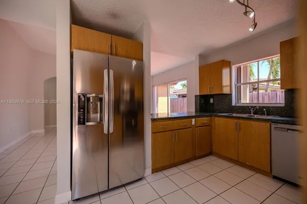 a kitchen with stainless steel appliances granite countertop a refrigerator and a sink