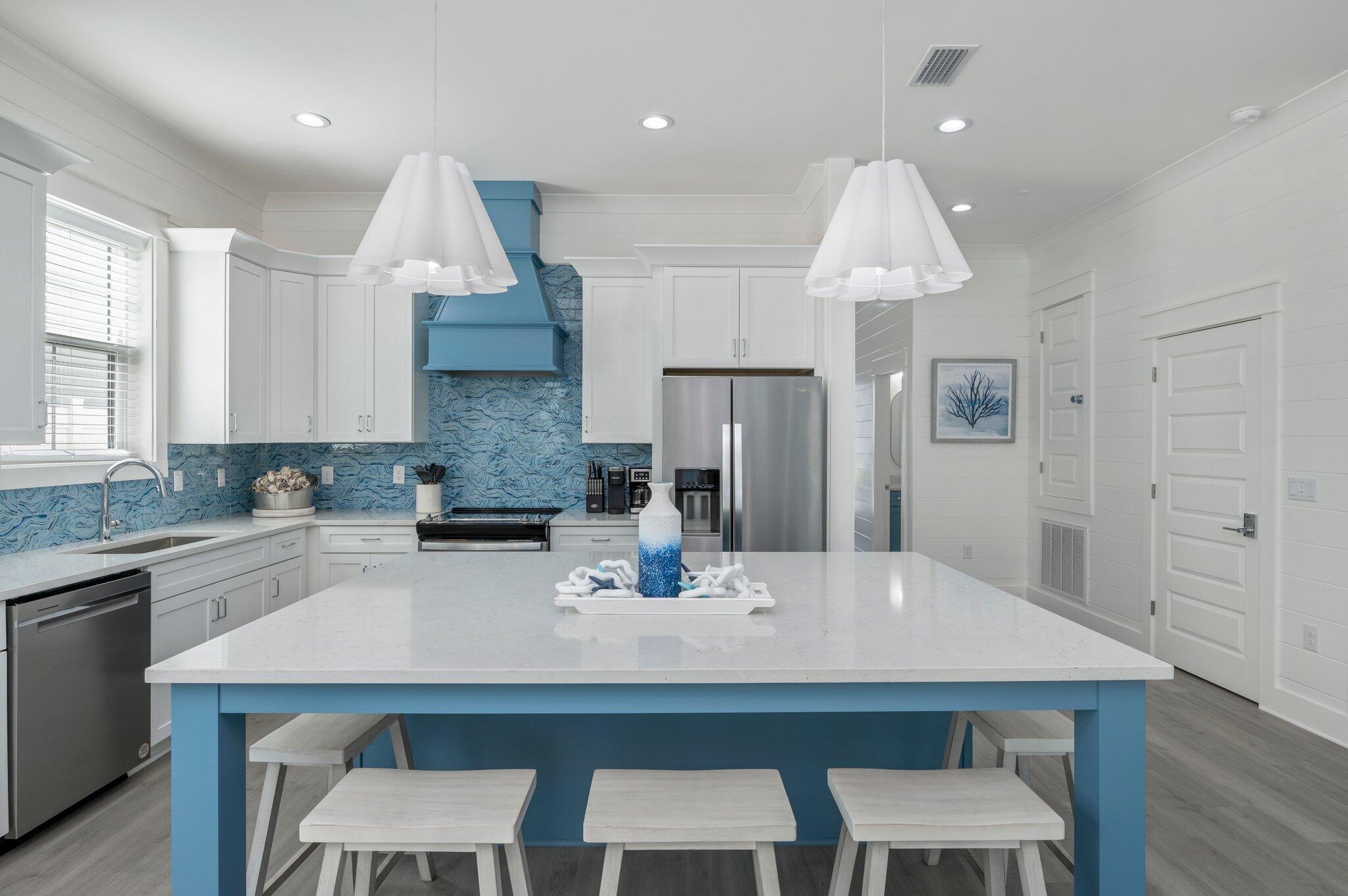 4553 Luke Avenue Destin, FL 32541 - Photo 15 of 70 a kitchen with stainless steel appliances granite countertop a kitchen island a stove a table and chairs in it
