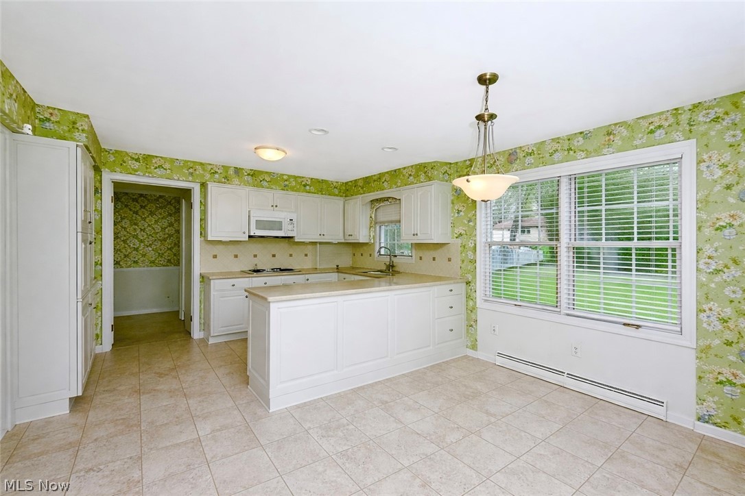 365 Sand Run Road Akron, OH 44313 - Photo 8 of 22 Kitchen featuring white cabinetry, a central island, tile flooring, and a large window with blinds