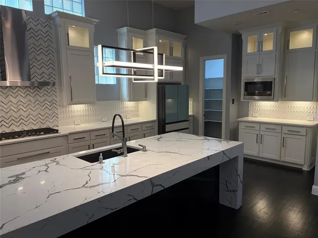 a kitchen with stainless steel appliances a sink and cabinets