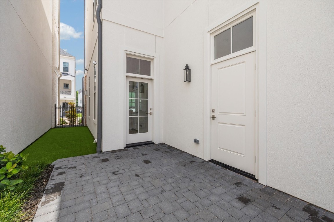 207 Sutton Row Place Houston, TX 77024 - Photo 12 of 30 Private courtyard features patio and artificial turf, accessible from glass door in house, side door to garage and back gate from curb.