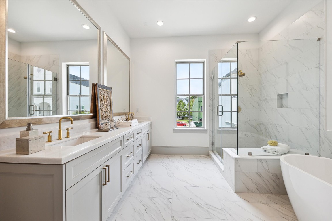 207 Sutton Row Place Houston, TX 77024 - Photo 15 of 30 a bathroom with a double vanity sink large mirror and a bathtub