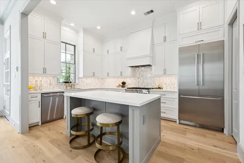 a kitchen with white cabinets stainless steel appliances and a center island