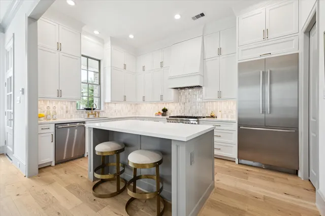 a kitchen with white cabinets stainless steel appliances and a center island