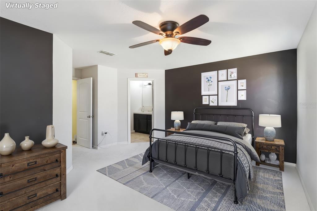 559 Siesta Key Avenue Tavares, FL 32778 - Photo 11 of 24 a bedroom with a bed and a chandelier