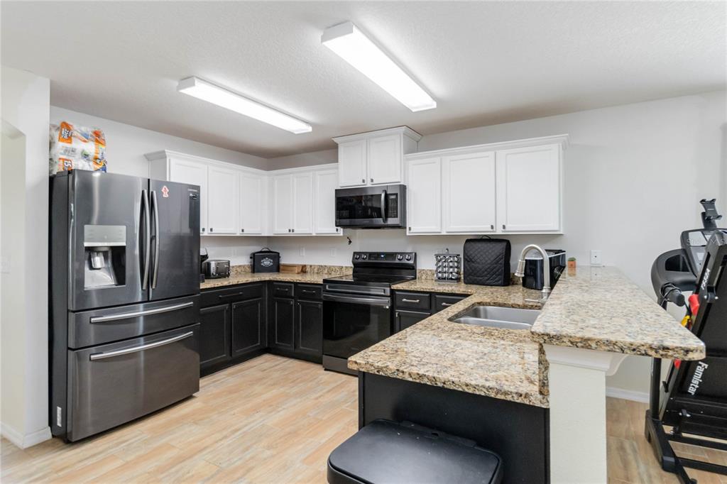 559 Siesta Key Avenue Tavares, FL 32778 - Photo 5 of 24 a kitchen with granite countertop stainless steel appliances and wooden cabinets