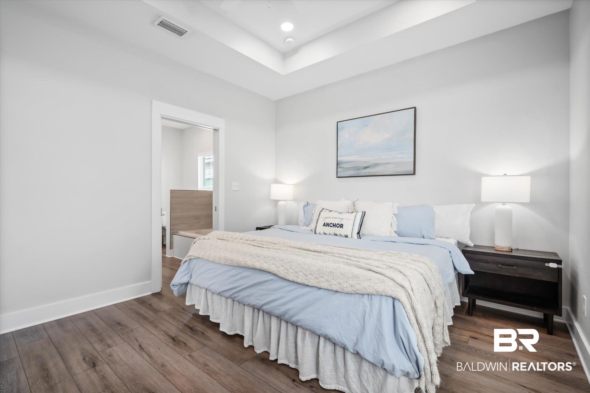 8056 Carmel Circle Foley, AL 36535 - Photo 11 of 28 Bedroom with a tray ceiling, dark hardwood / wood-style floors, and ensuite bathroom