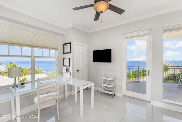 a bedroom with a bed a flat screen tv and a large window