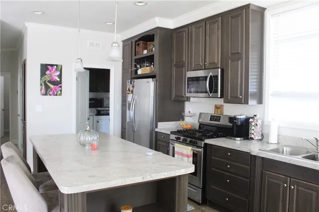 a kitchen with kitchen island a sink appliances and cabinets