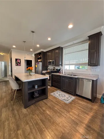 a kitchen with stainless steel appliances kitchen island granite countertop a stove and a sink