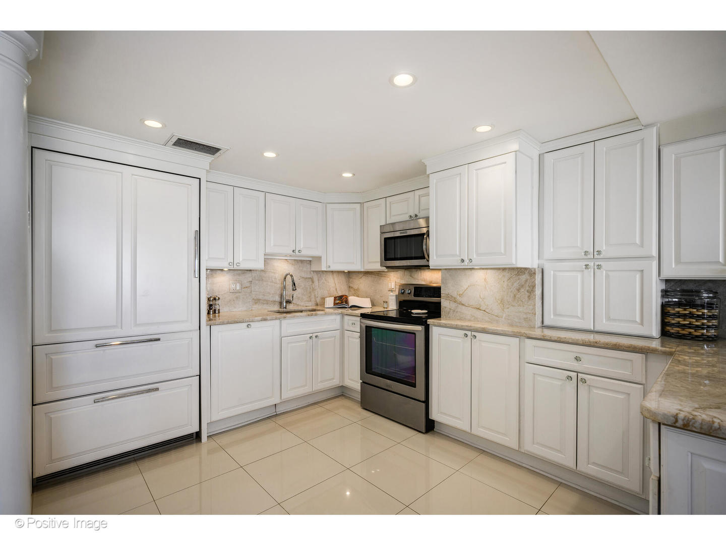 175 East Delaware Place, Unit 7107 Chicago, IL 60611 - Photo 9 of 24 a kitchen with white cabinets and white appliances