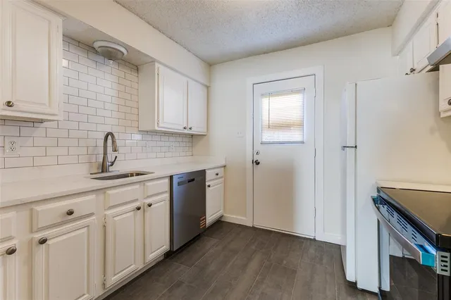a kitchen with white cabinets and sink