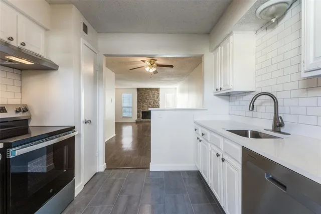 a kitchen with sink a refrigerator and cabinets