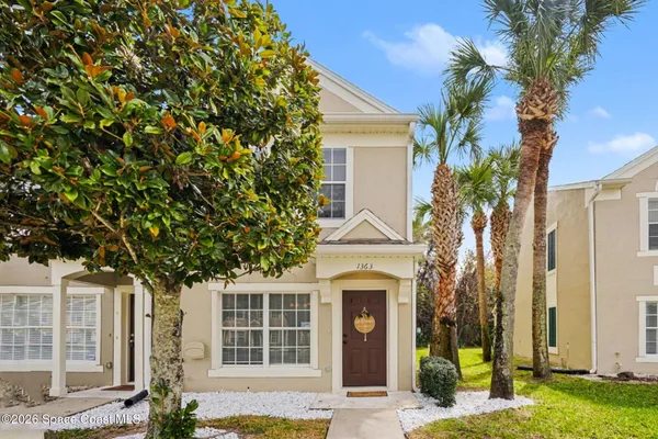 a front view of a house with a tree
