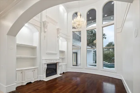 a view of a livingroom with wooden floor and a fireplace