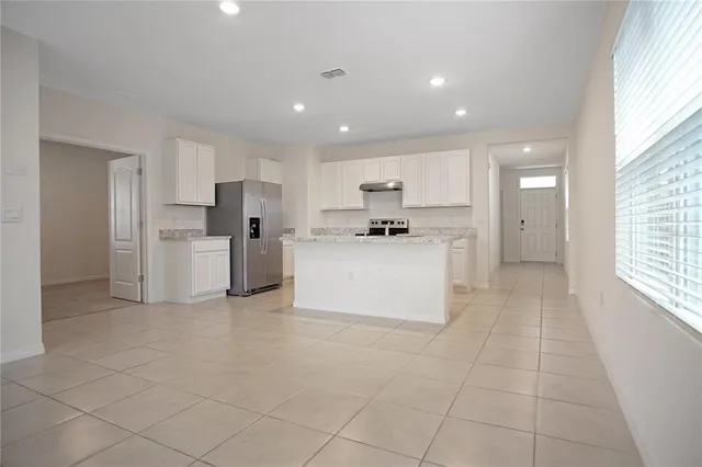 a kitchen with stainless steel appliances a refrigerator sink and cabinets
