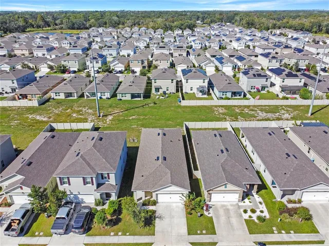 an aerial view of residential houses with outdoor space and ocean view
