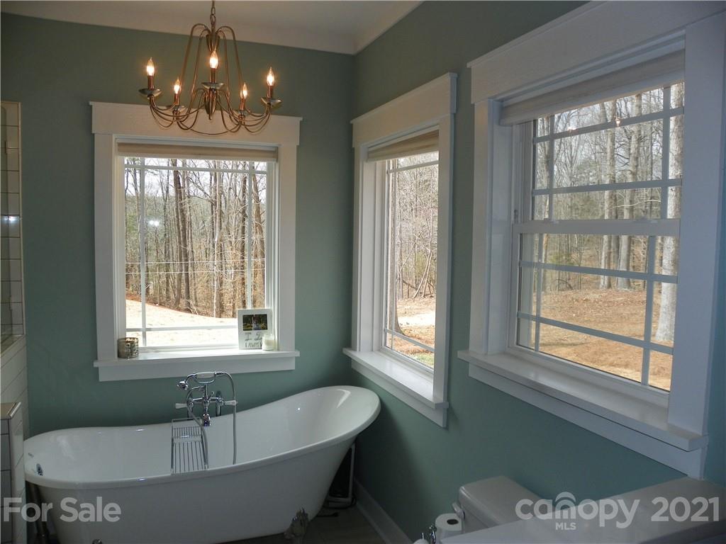 10617 Fink Road Mount Pleasant, NC 28124 - Photo 26 of 45 a spacious bathroom with a bathtub a chandelier and windows