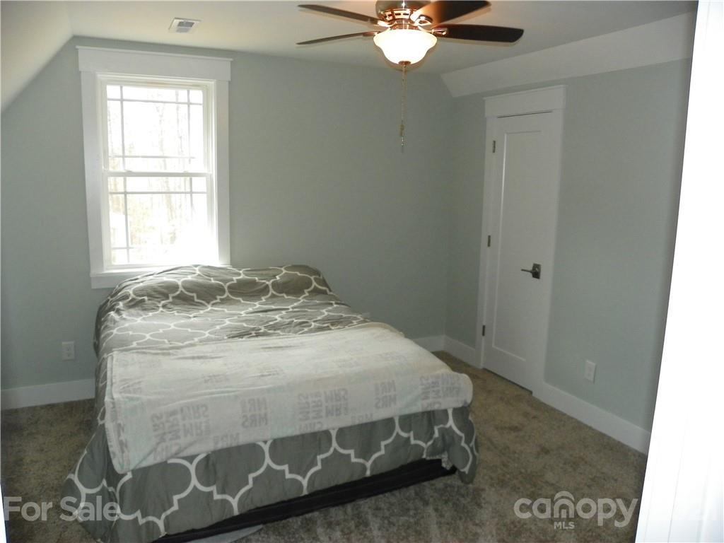 10617 Fink Road Mount Pleasant, NC 28124 - Photo 32 of 45 a bedroom with a bed and a chandelier
