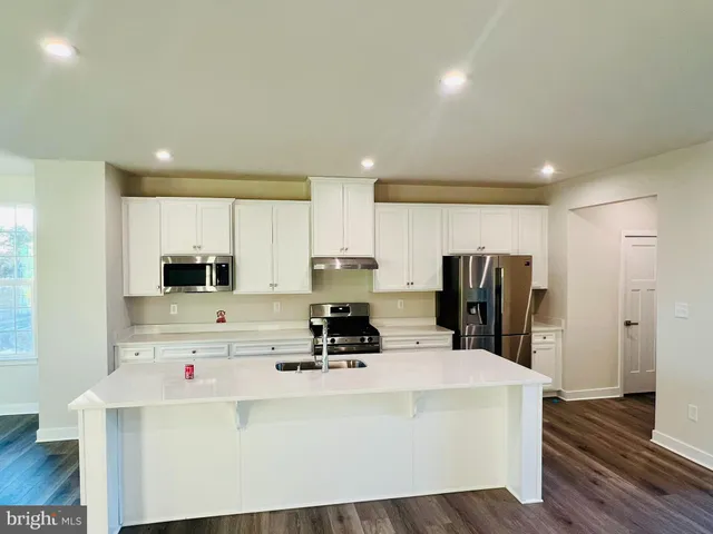 a kitchen with cabinets a refrigerator and a stove top oven