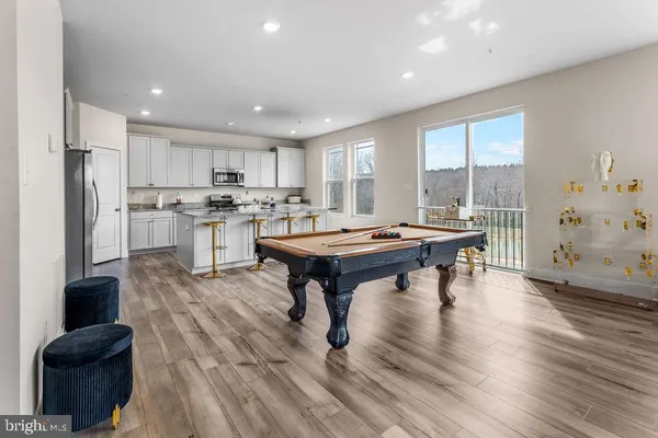 a kitchen with a table chairs refrigerator and a window