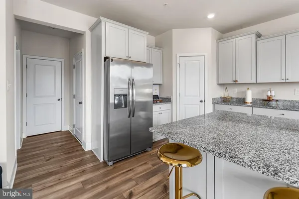 a kitchen with granite countertop a refrigerator and a sink