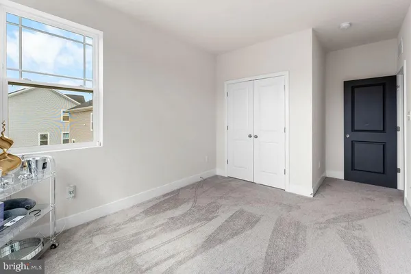 an empty room with closet and windows