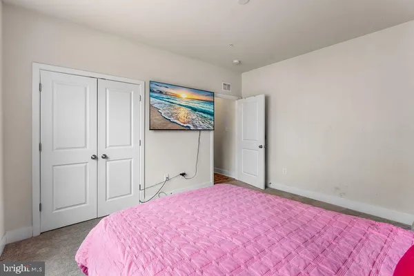 a bedroom with a bed and a painting on the wall